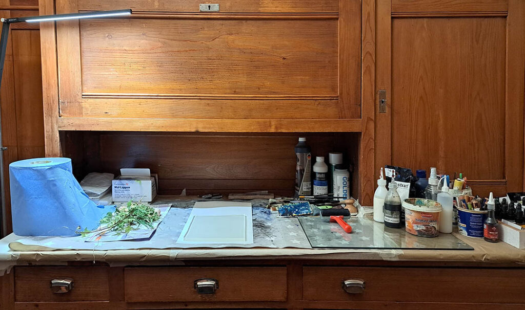 Schreibtisch in einem Kloster mit Utensilien für Monotypie