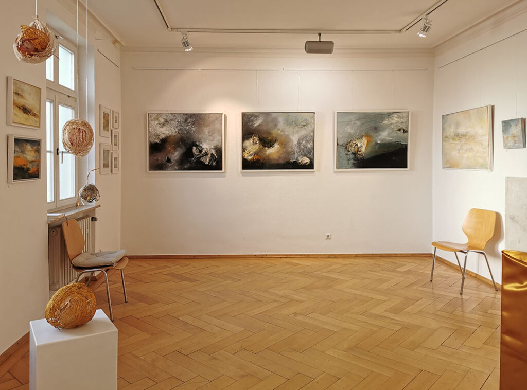 Ausstellungsansicht: mehrere Gemälde und Objekte in einem Galerieraum