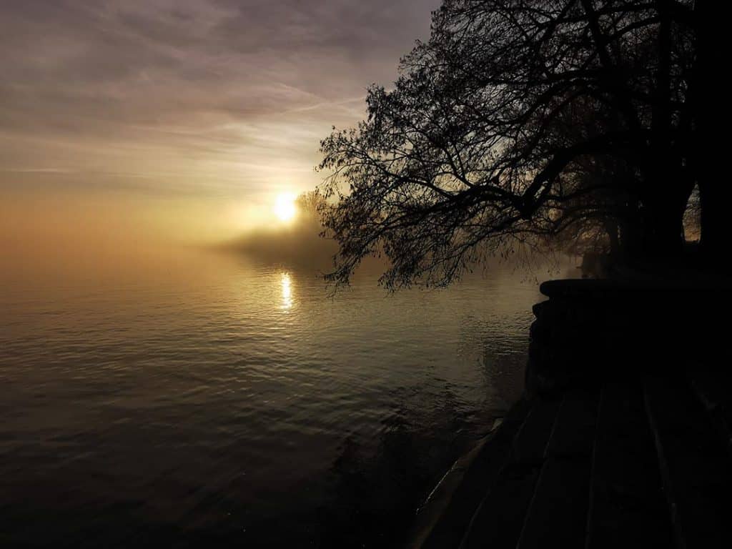 Foto von Sonnenuntergang im Nebel am Bodensee. Die Stimmung wirkt sehr still